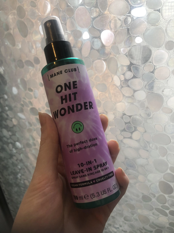BuzzFeed Writer holding a bottle of the One Hit Wonder spray