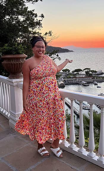 a reviewer wearing the orange and pink floral dress