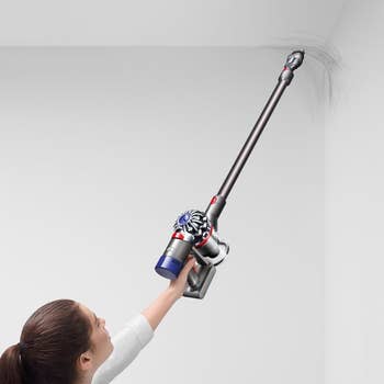 a model using the extended vacuum to clean the corner of a all