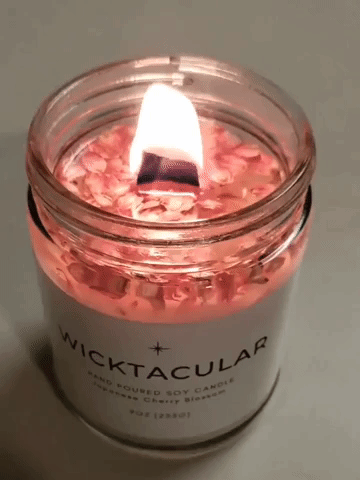 Video of pink candle with cherry blossoms and woodwick lit