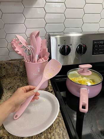 reviewer holding one of the pink spatulas