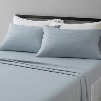 A neatly made furniture  with striped bedding and pillows