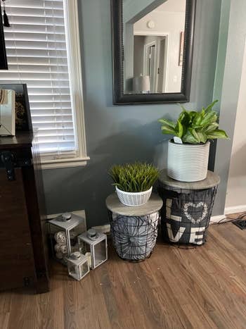 a reviewer uses the table to store pillows and display potted plants on top