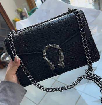 reviewer holding achromatic purse