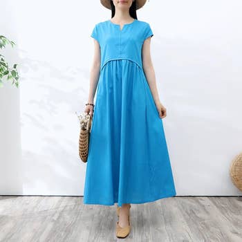 model in a blue flowing short-sleeved midi dress 