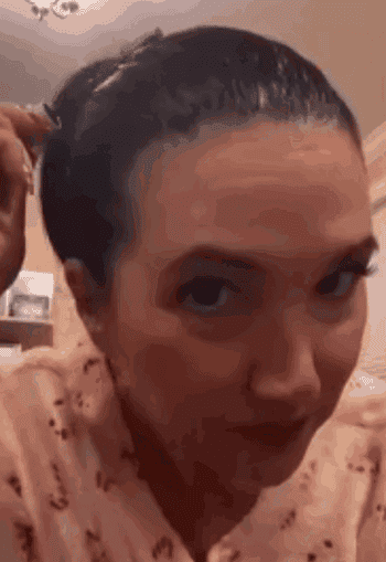 GIF of idiosyncratic applying hairsbreadth attraction portion wearing a patterned shirt, demonstrating a haircare routine