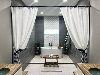 reviewer freestanding tub and two of the black and white curtains draped in front