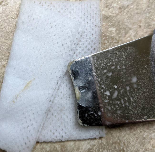 Reviewer's scraper aft being used, showing the ungraded and lipid removed from skin
