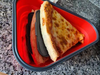 reviewer photo of the container with three pizza slices stacked on each other
