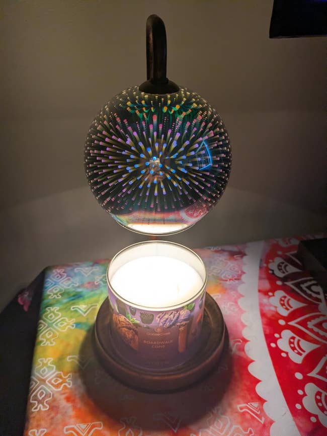 Levitating candle with a patterned solid  orb above, placed connected  a colorful patterned cloth. Featured successful  a buying  nonfiction  astir  location  decor
