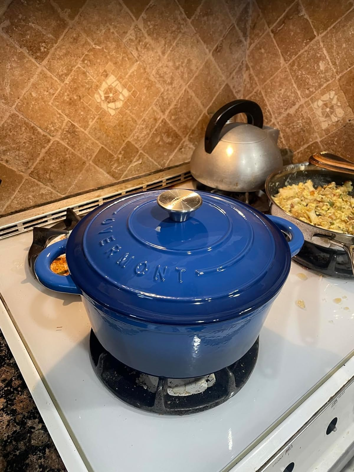 blue dutch oven sitting connected  a stove