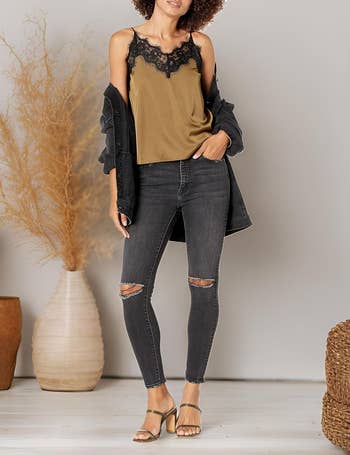 a model wearing the light brown lacy tank with jeans and heels