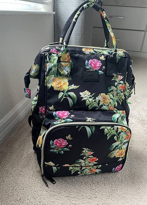 a reviewer photo of the backpack with a floral print 