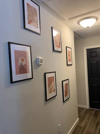 another reviewer's prints in black frames hung in a staggered pattern in the entryway of a home
