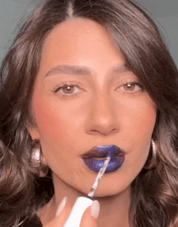 Model applying blue lip mask and peeling to reveal maroon lip stain
