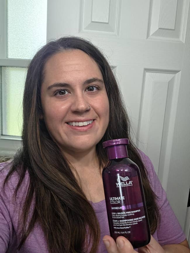 Person holding a vessel  of Wella Ultimate Color shampoo, smiling successful  a location  bath  setting