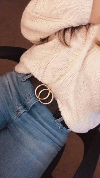 reviewer wearing faux leather belt with jeans and sweater