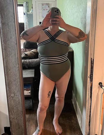 a reviewer wearing the bathing suit in green with black trim 