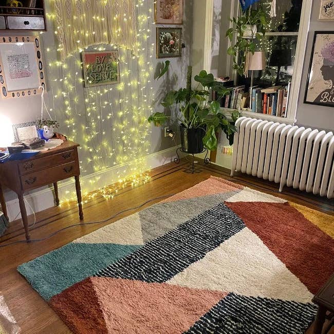 a review photo of the bold area rug in a living room 