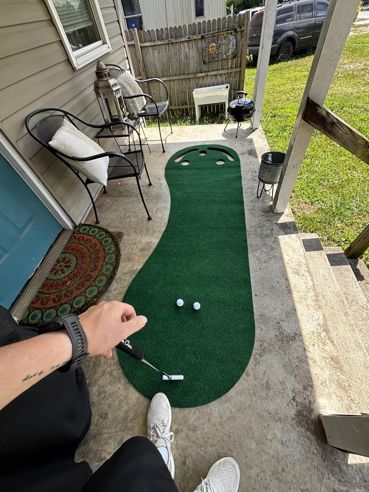 Reviewer connected  their structure  holding a putter with the location  putting greenish  successful  beforehand   of them 