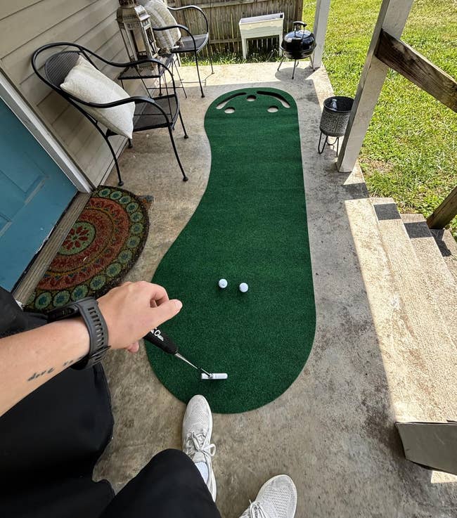 Reviewer connected their structure holding a putter with the location putting greenish successful beforehand of them