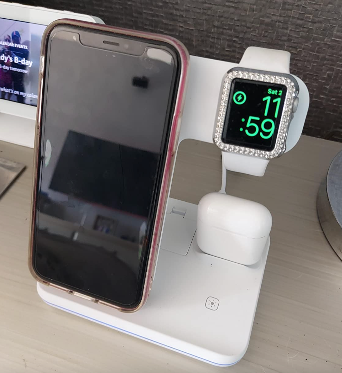 A white charging stand with slots for a phone, earbuds, and watch to charge 