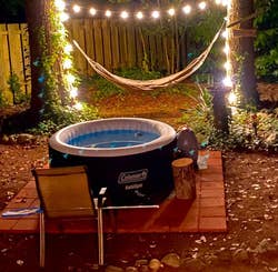the hot tub in a reviewer's backyard lit by fairy lights