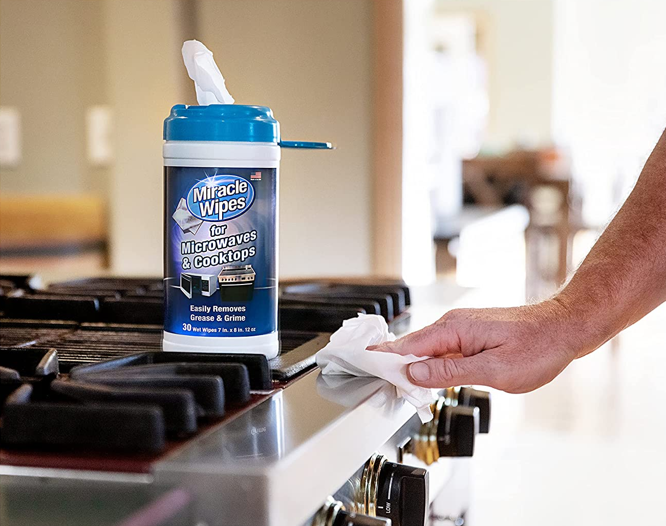 Model wiping oven next to container of open cleaning wipes