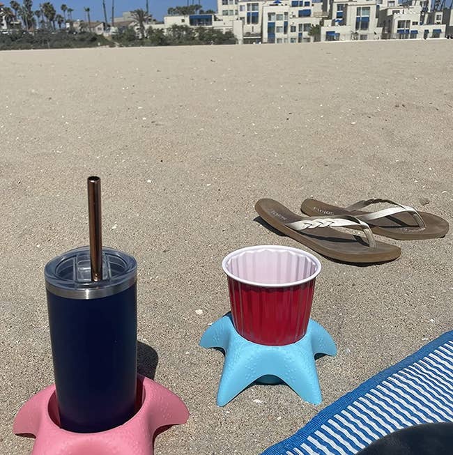 reviewer image of two beverages each in a starfish shaped sand coasters on the beach