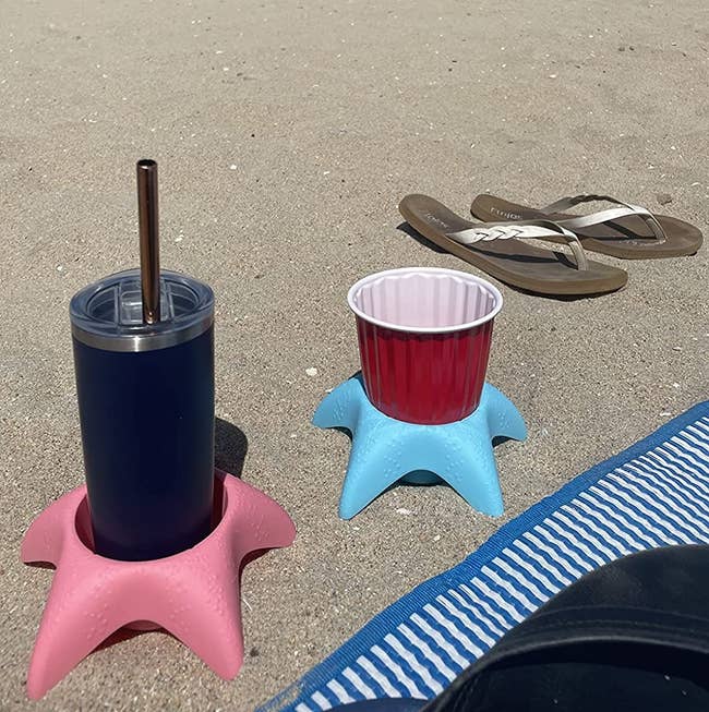 reviewer image of two beverages each in a starfish shaped sand coasters on the beach