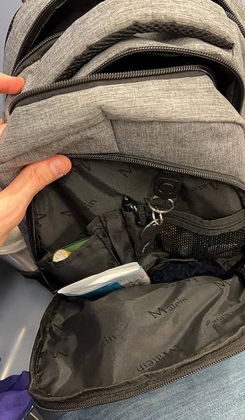 same reviewer showing outer compartment of backpack