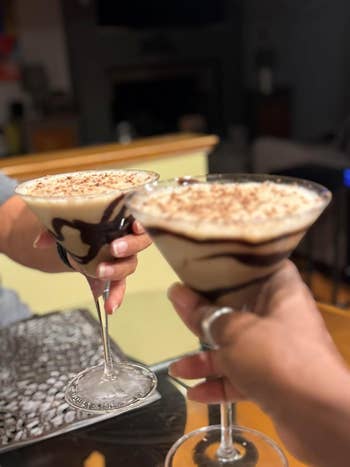 Two radical   toasting with chocolate-drizzled martini glasses, perchance  enjoying a dessert cocktail successful  a cozy setting