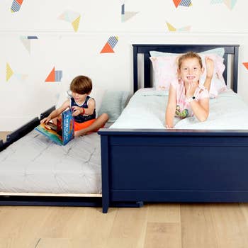 two kids on navy trundle bed