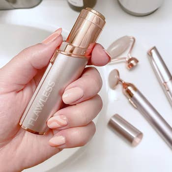 Model holding lipstick shaped rose gold hair removal tool 