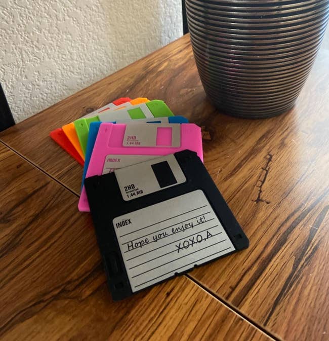 Table with a vase and several colorful floppy disk coasters
