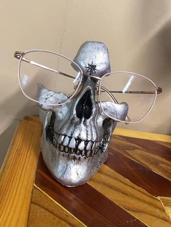 A silver skull with a reviewer's glasses displayed on it