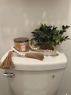 reviewer showing the beads on a tray that's over the toilet