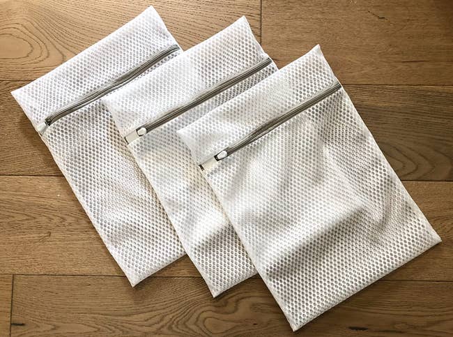 Three white zippered honeycomb mesh bags 