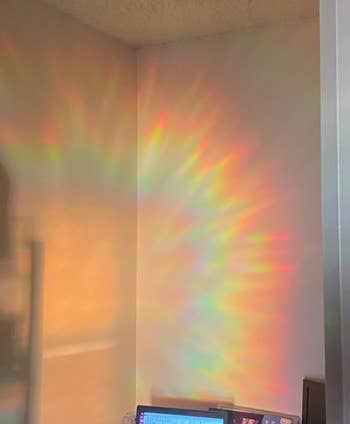 rainbow cast on a wall above a desk