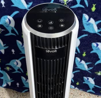 Levoit operation instrumentality connected a patterned carpet with a shark-printed backdrop, featuring interaction controls connected top
