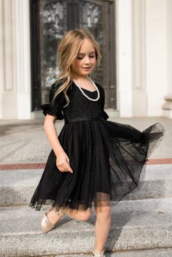 Model is wearing the same dress, but for a younger kid