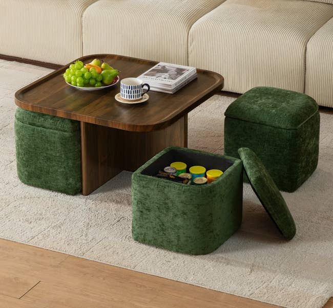 Coffee array  with a effect   bowl, mug, and book. Two greenish  ottomans, 1  unfastened  with retention  inside, are placed adjacent  to a sofa