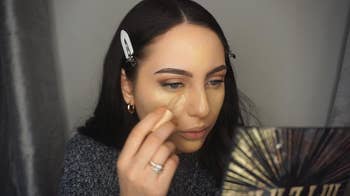 a reviewer wearing the clips to hold their hair out of their face while they do their makeup