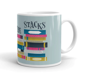 second half of the mug with a blue backdrop and book stacks that reads in black letters 