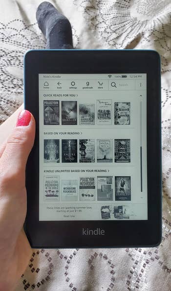 a reviewer showing the main menu of the kindle with tons of books on screen