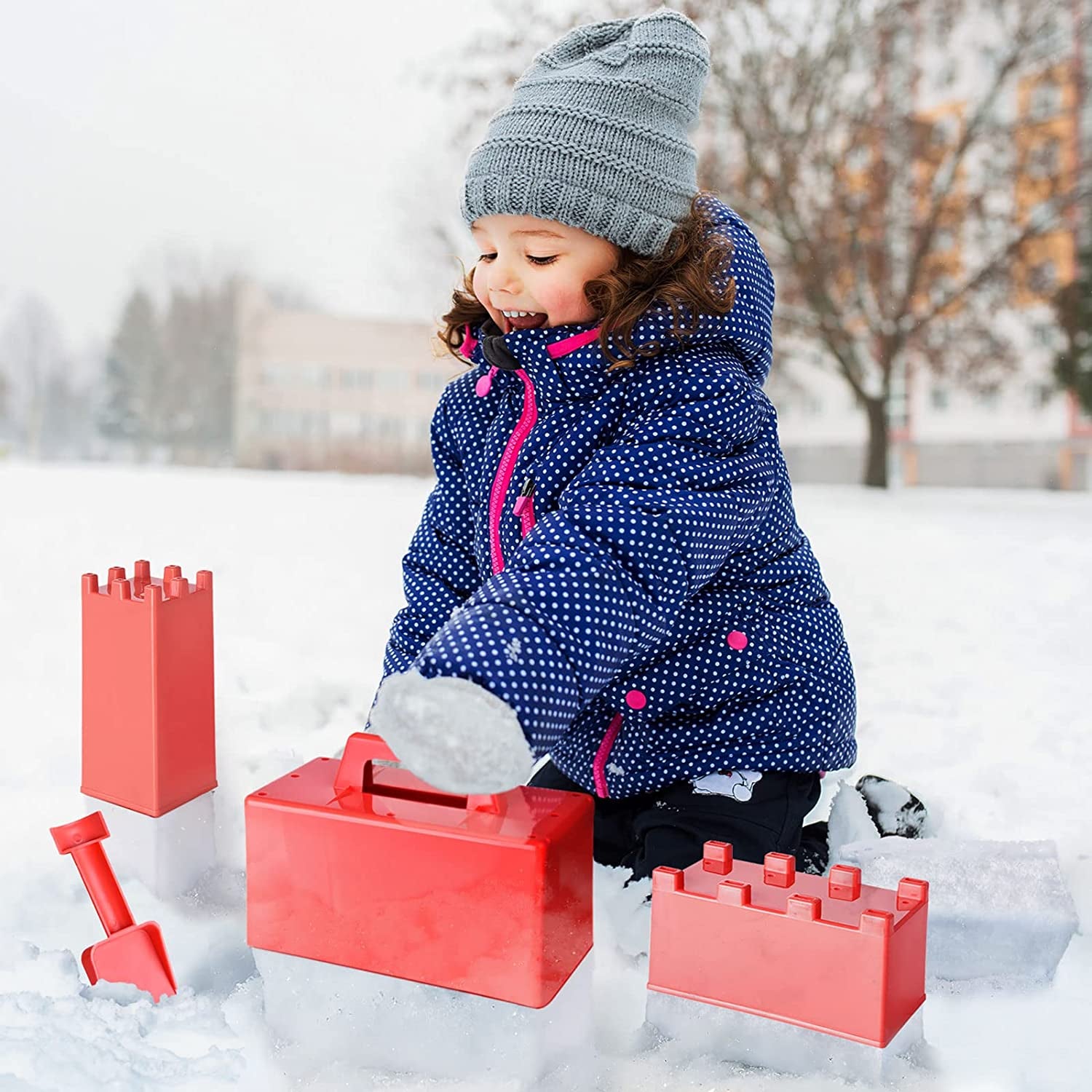 a child using red snow fort building molds