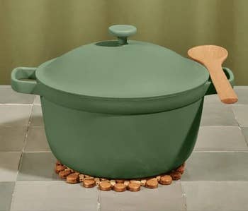 the green perfect pot with a wooden spoon resting on one of its handles