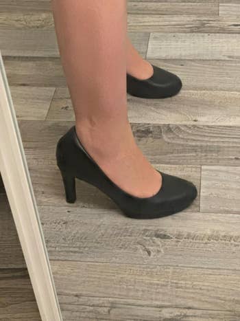 Person wearing classical  high-heeled pumps connected  a woody  floor, showcasing footwear benignant   for imaginable  acquisition  successful  a buying  article