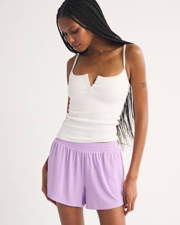 Person wearing a fitted sleeveless apical  with fastener  item  and escaped   shorts, showcasing casual, comfy  attire
