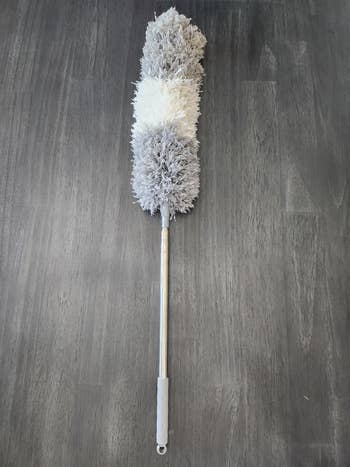 Extendable duster with fluffy grey  and achromatic  sections, perfect  for reaching precocious   oregon  hard-to-access areas successful  location  cleaning
